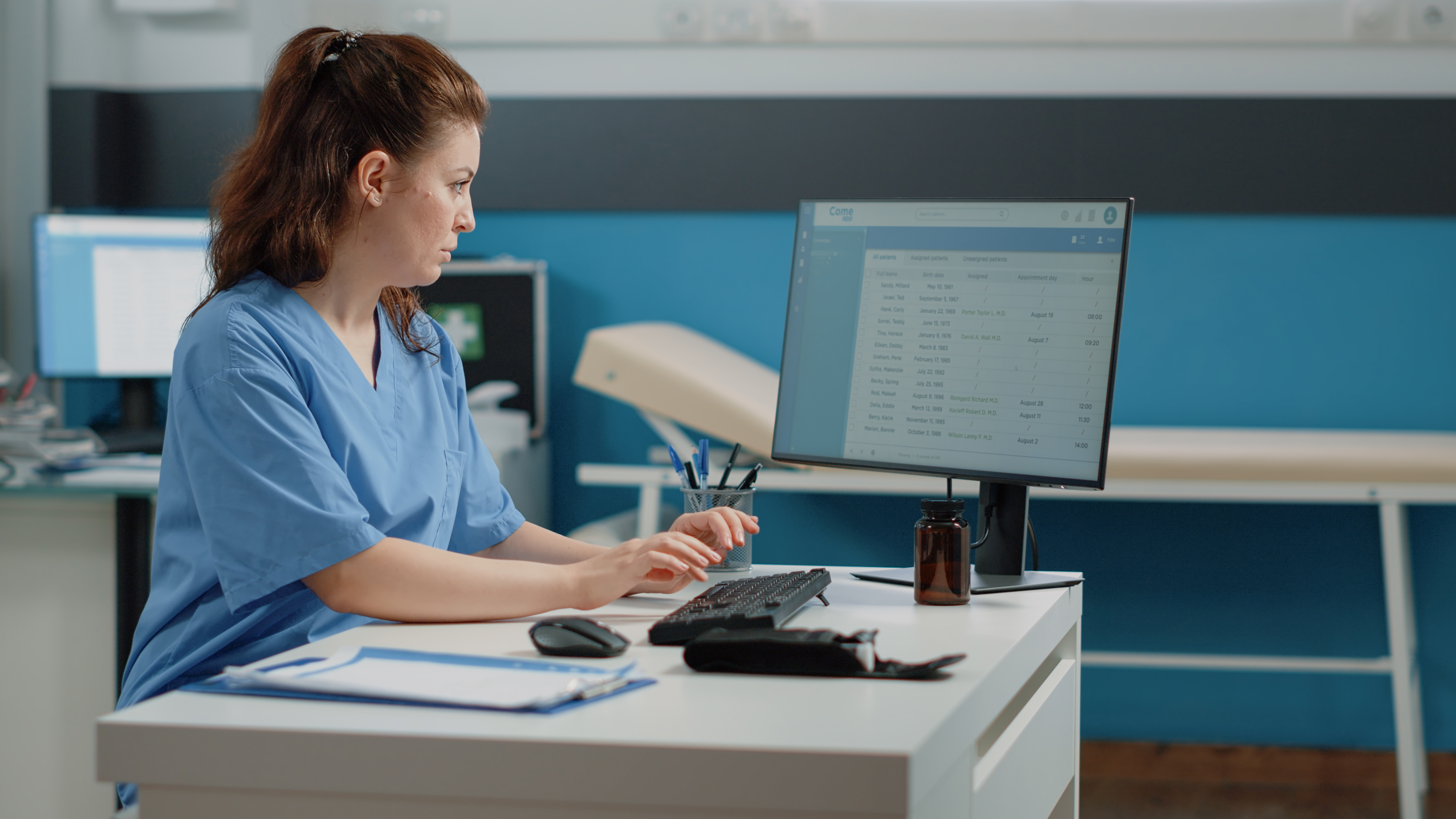 NHS staff / hospital worker looking at data on a computer