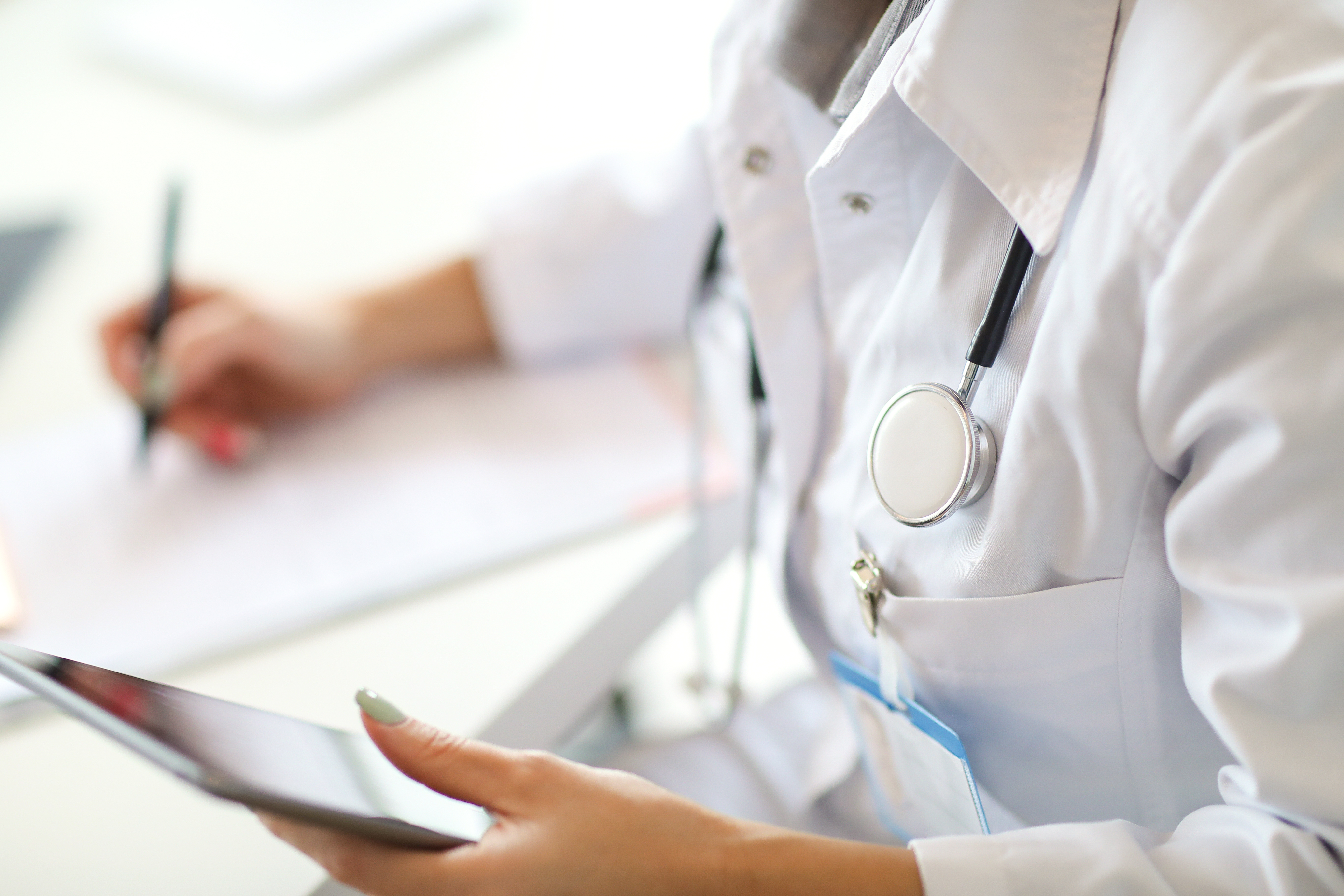 Doctor holding an ipad / tablet whilst working