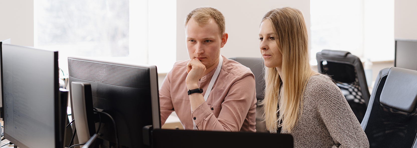 Two people looking at computer monitors