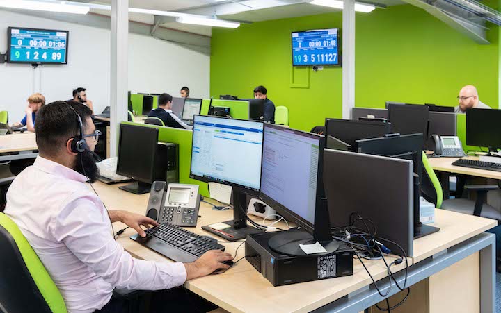 Service desk workers sat at desks with computers in front of them.